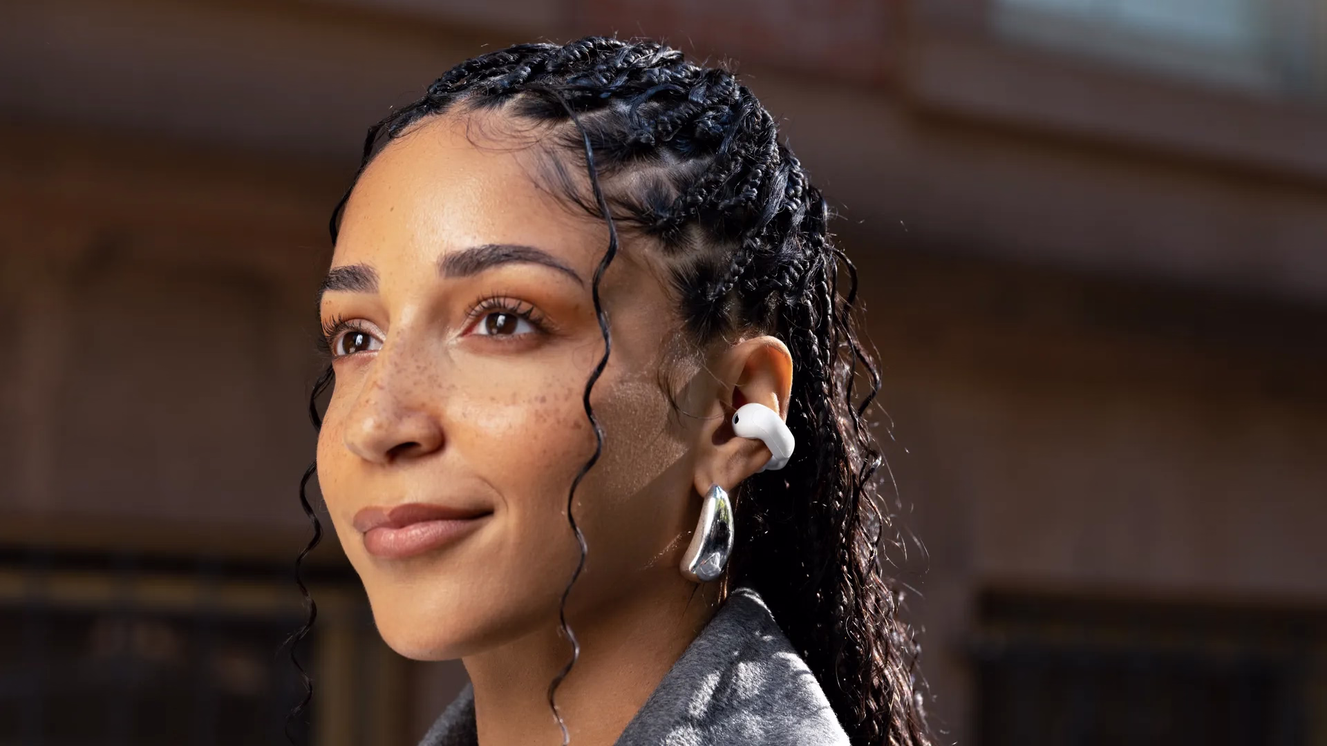 Woman wearing Bose Ultra Open Earbuds.