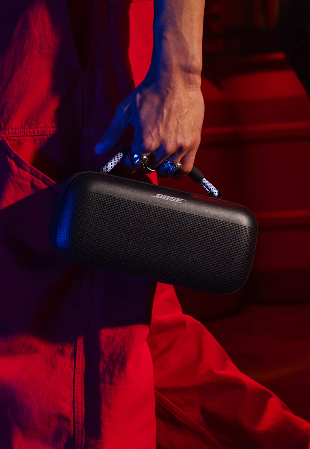 Man carrying a Bose SoundLink Max Portable Speaker with a Black / Chilled Lilac rope handle