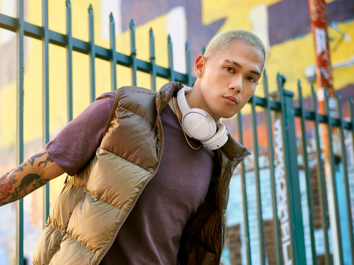 Young man with Bose QuietComfort Headphones around his neck