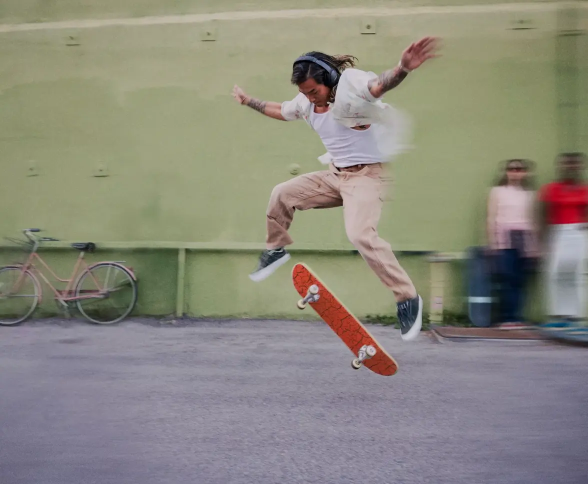 Skateboarder wearing QuietComfort 45 headphones while performing a trick