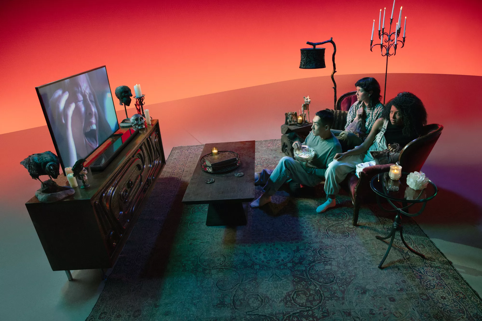 Friends sitting on the couch, eating popcorn, and watching a scary movie with Smart Soundbar Ultra