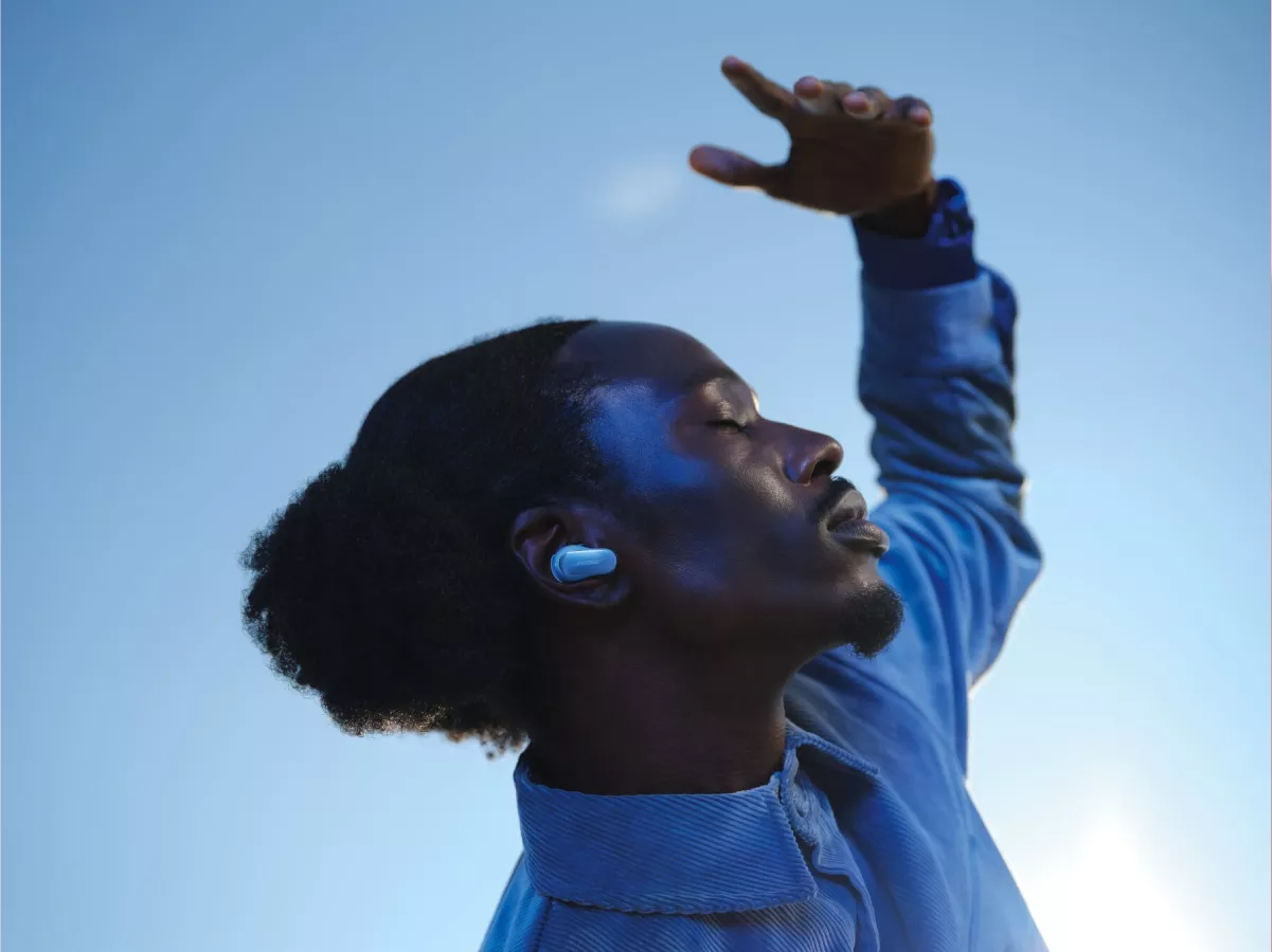 Guy outside with clear blue sky background wearing QuietComfort Ultra Earbuds