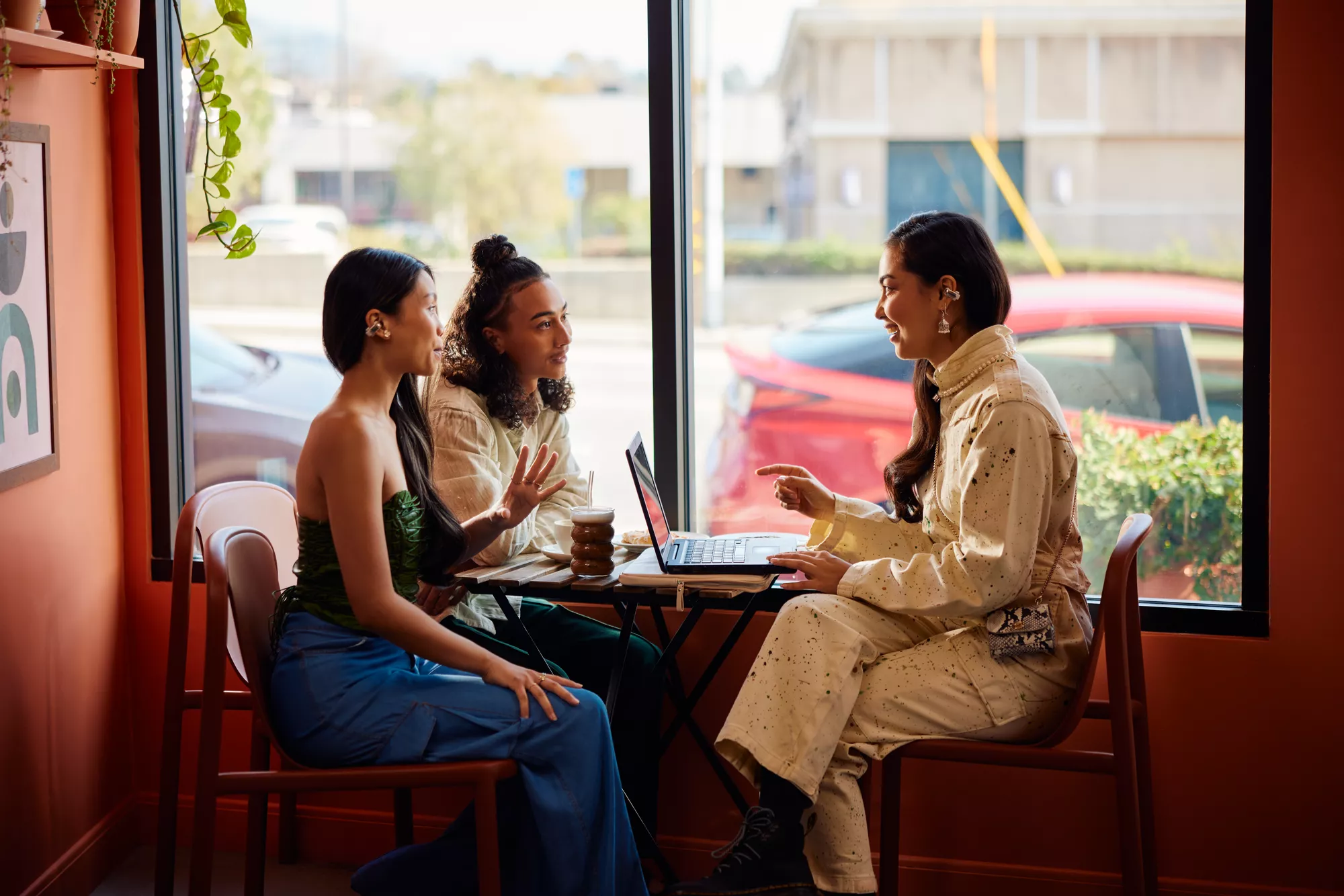 People in a meeting at a café wearing Bose Ultra Open Earbuds