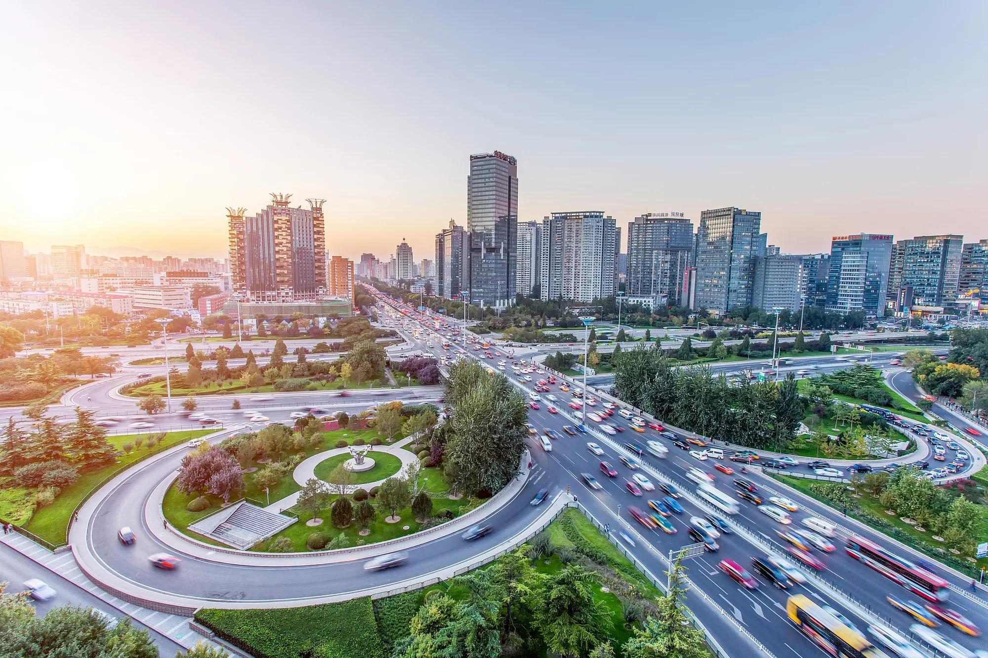 A city skyline and highway overpasses with cars in motion
