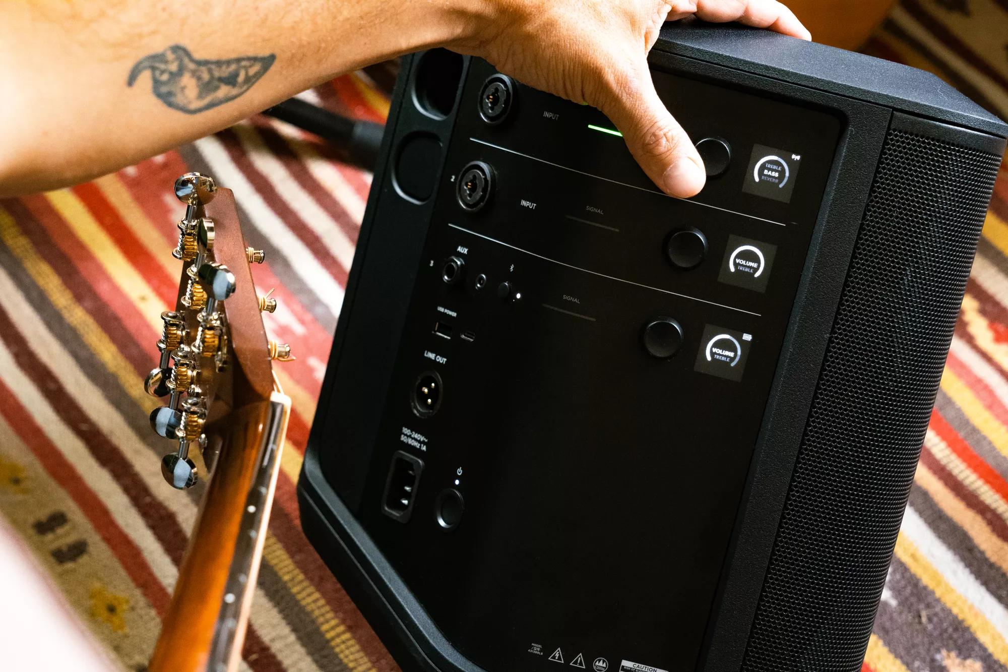 Man adjusting the bass of the Bose S1 Pro+ Portable Bluetooth Speaker System