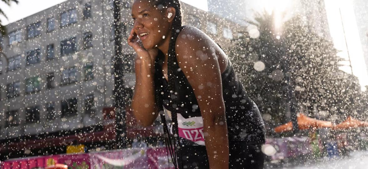 Une femme qui se fait arroser &agrave; l&rsquo;ext&eacute;rieur en portant les &eacute;couteurs QuietComfort&nbsp;II de Bose