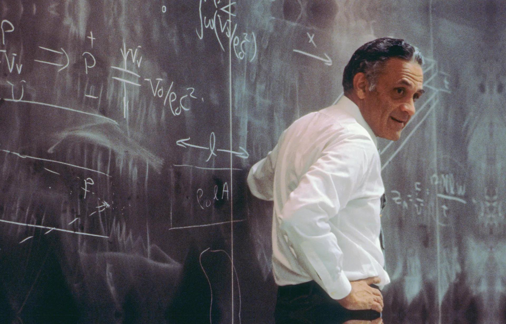 Dr. Bose in front of a blackboard