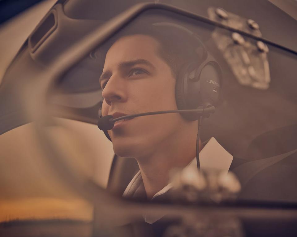 Un homme pilote portant le casque d’aviation Bose A30 dans un avion