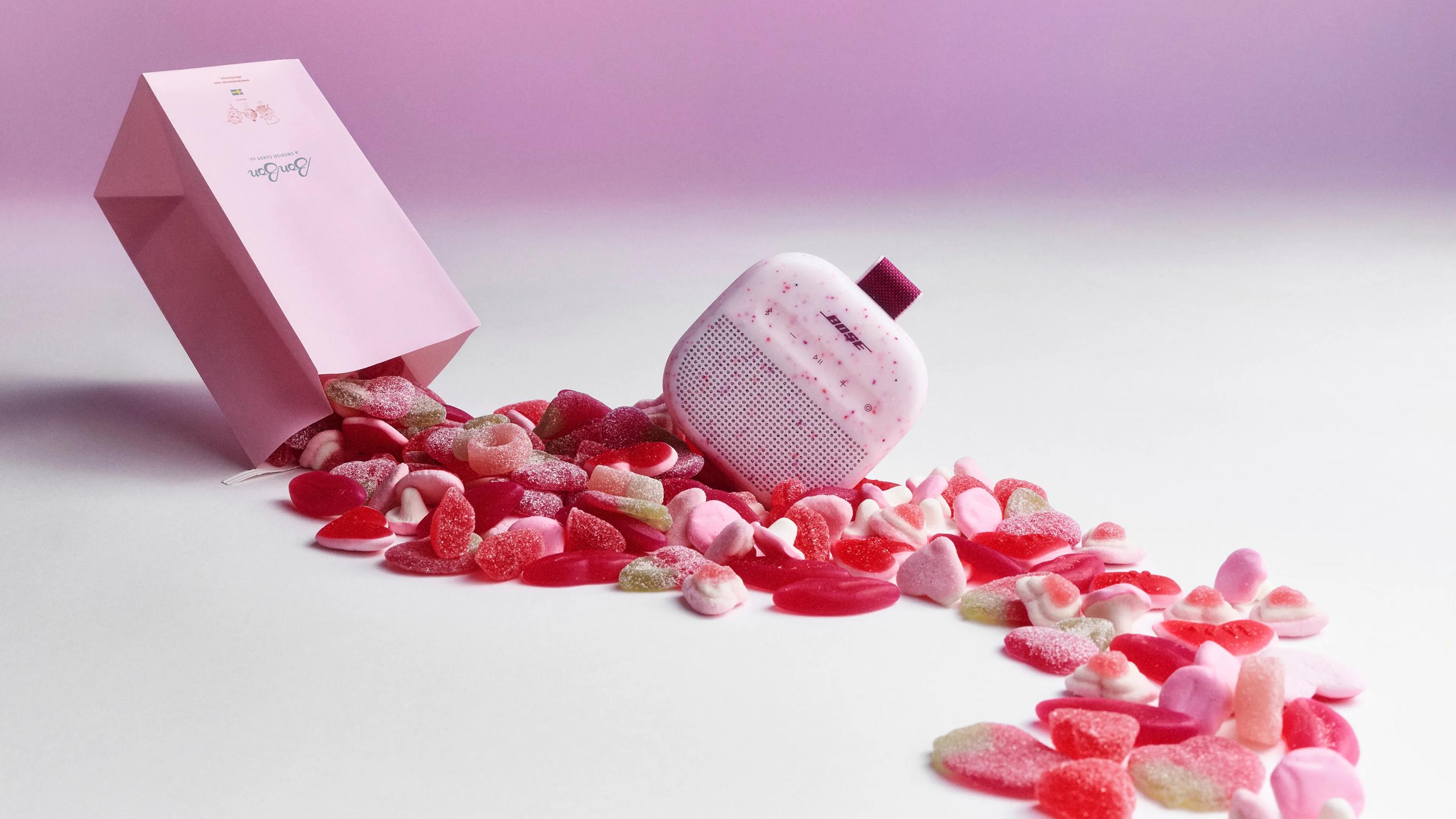 An assortment of BonBon candy and a Bose SoundLink Micro Portable Speaker (2nd Gen) in Petal Pink. 