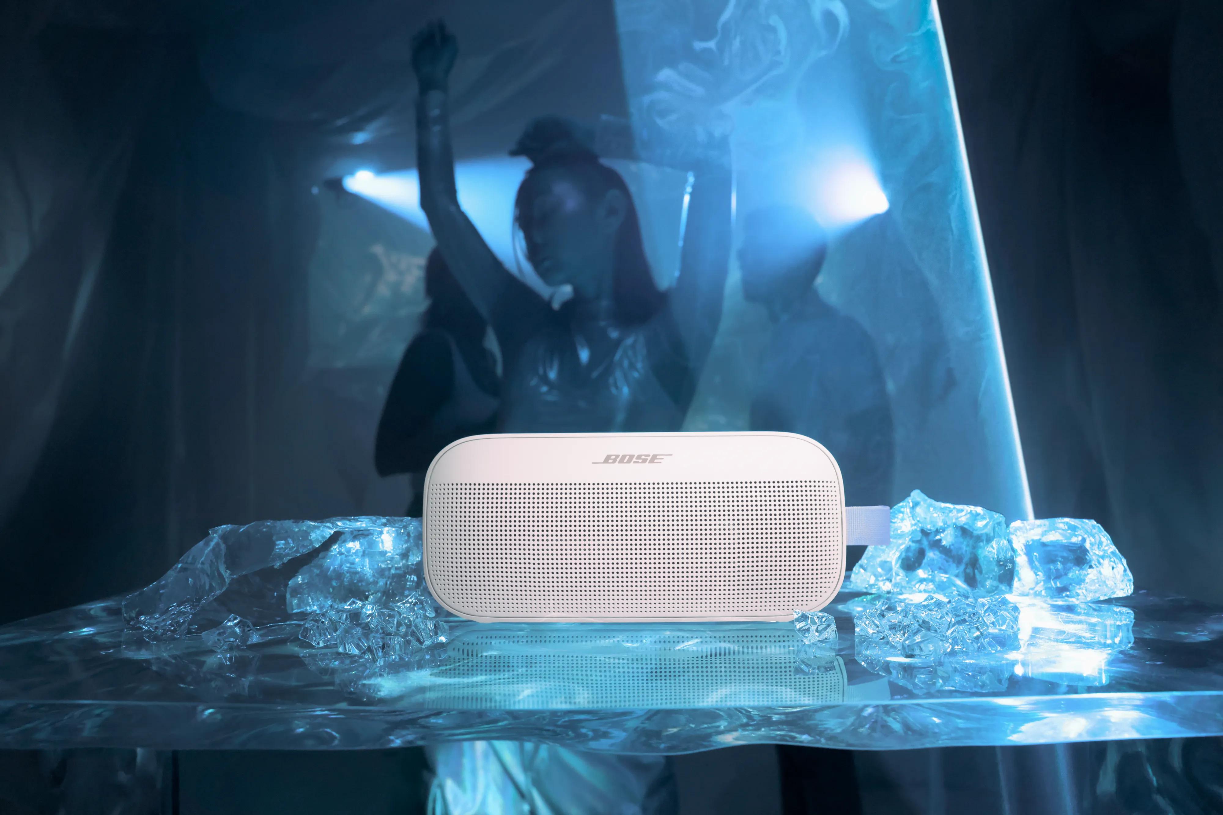 Bose SoundLink Flex 2nd Gen in Fog Gray with woman dancing in front of blue lights in the background   