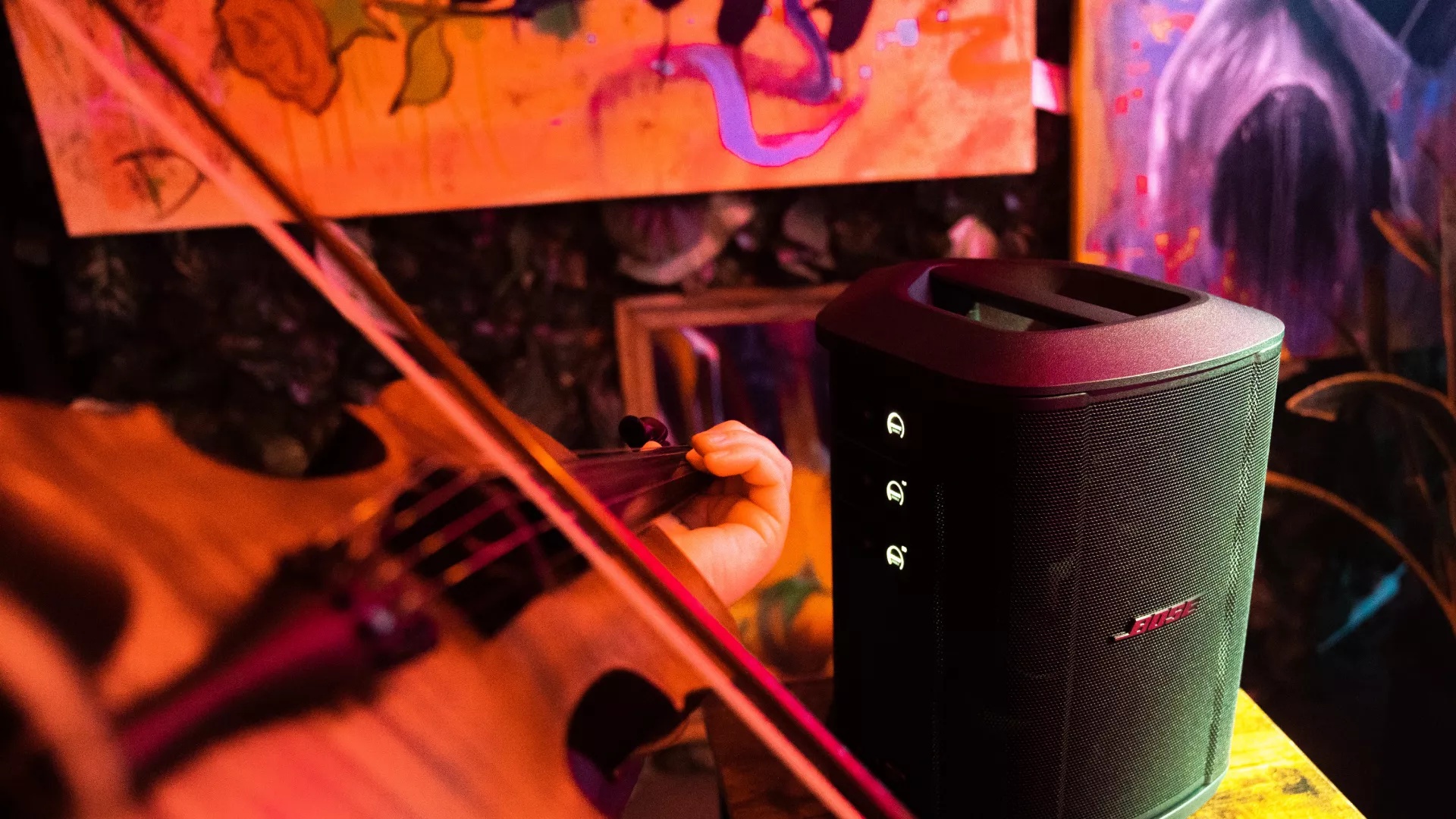 Musician playing guitar in bar with Bose S1 Pro+ Portable Bluetooth® Speaker System