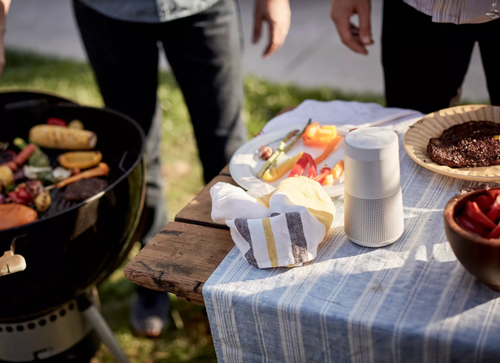 Bose SoundLink Revolve II Bluetooth Speaker on a table at a barbecue