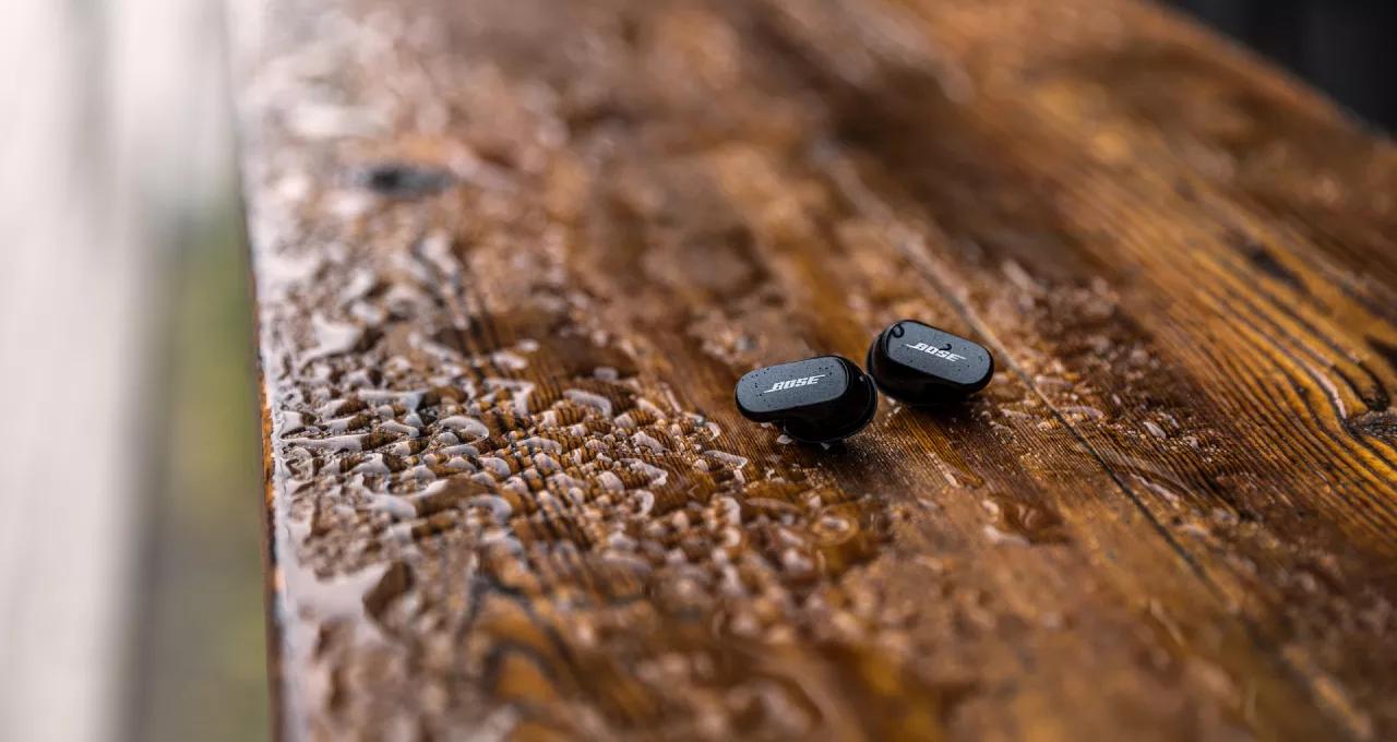 Bose QuietComfort Earbuds II on a wet bench outside