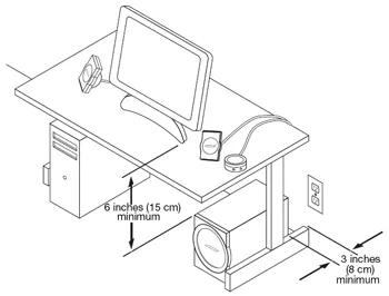 Speakers placed on each side of laptop computer with the bass module on the floor