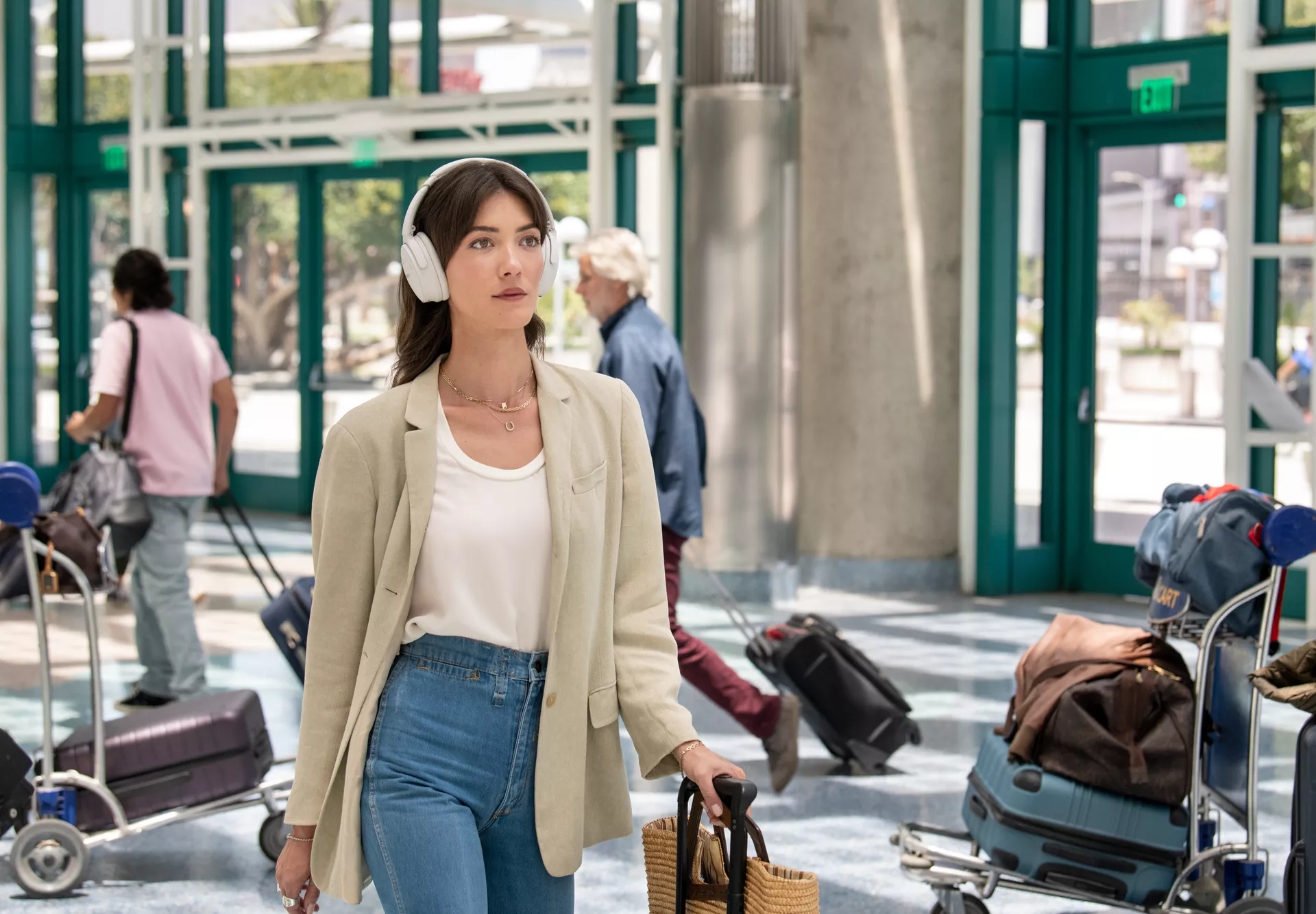 Woman walking through airport and using QuietComfort Headphones