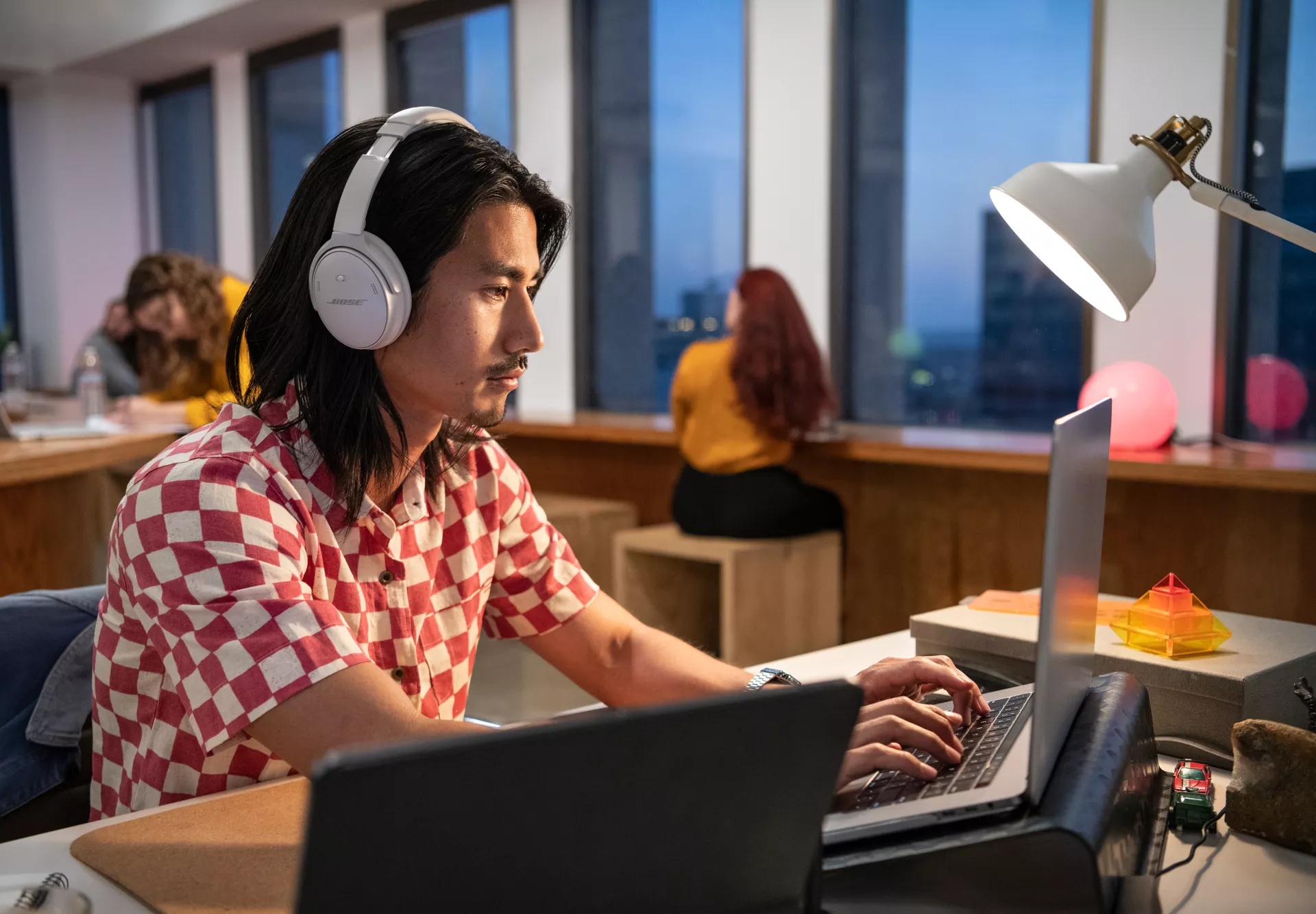 Man working in office wearing Bose QuietComfort Headphones to reduce background noise