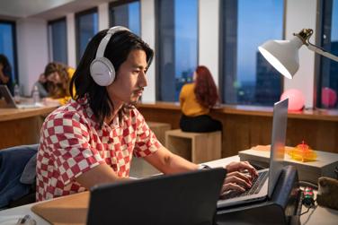Man working in office wearing Bose QuietComfort Headphones to reduce background noise