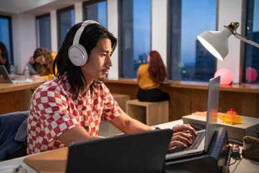 Man working in office wearing Bose QuietComfort Headphones to reduce background noise