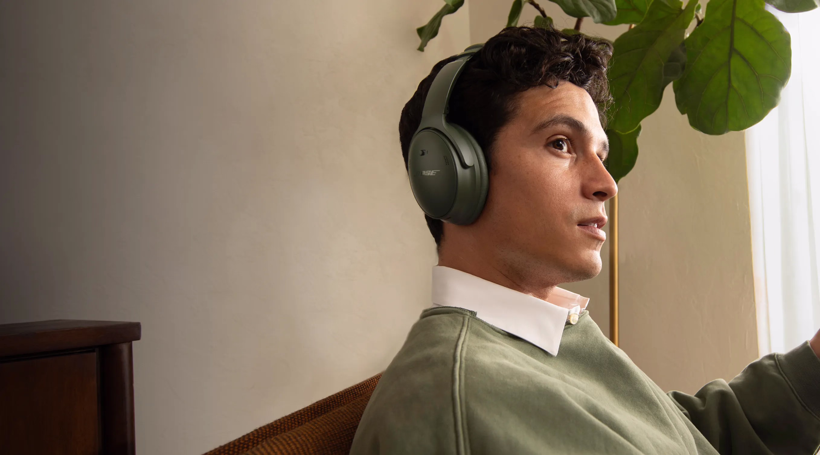 Man wearing Bose QuietComfort Headphones outside in Cypress Green.