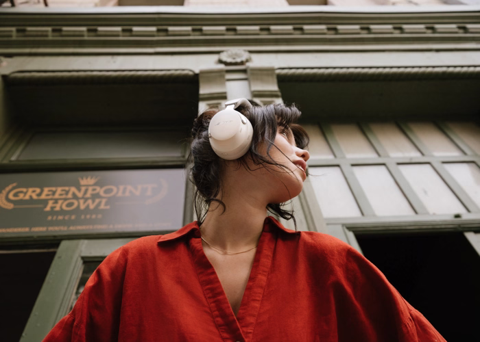 Woman wearing Bose QuietComfort Ultra Headphones (2nd Gen) while in front a building in the city.