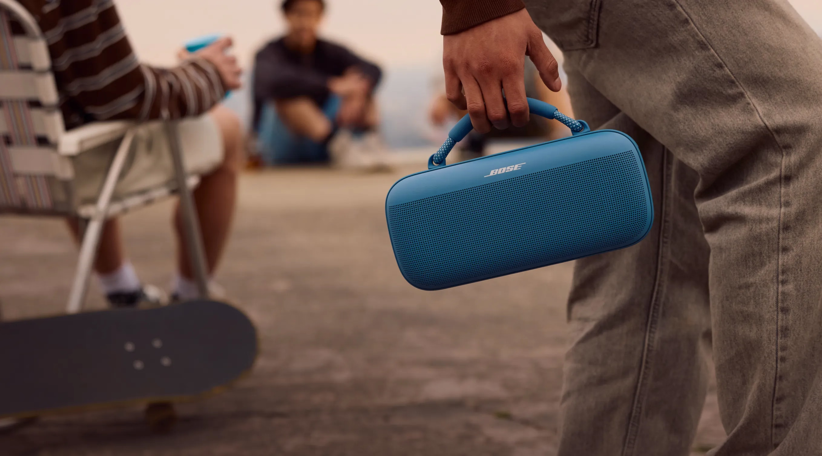 Un homme qui transporte une enceinte portative Bose SoundLink Max &agrave; l&rsquo;ext&eacute;rieur.