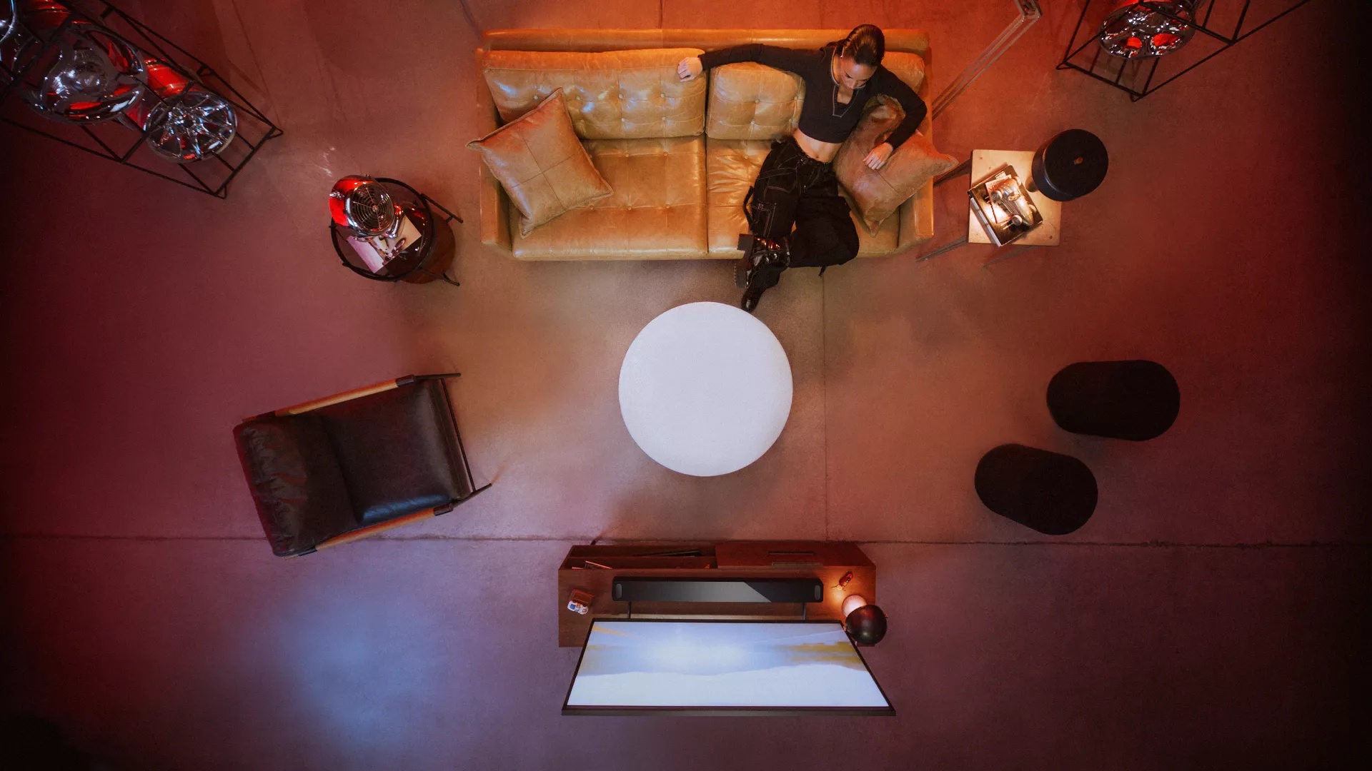 Aerial view of a woman sitting on couch and watching movie with a Bose Smart Ultra Soundbar