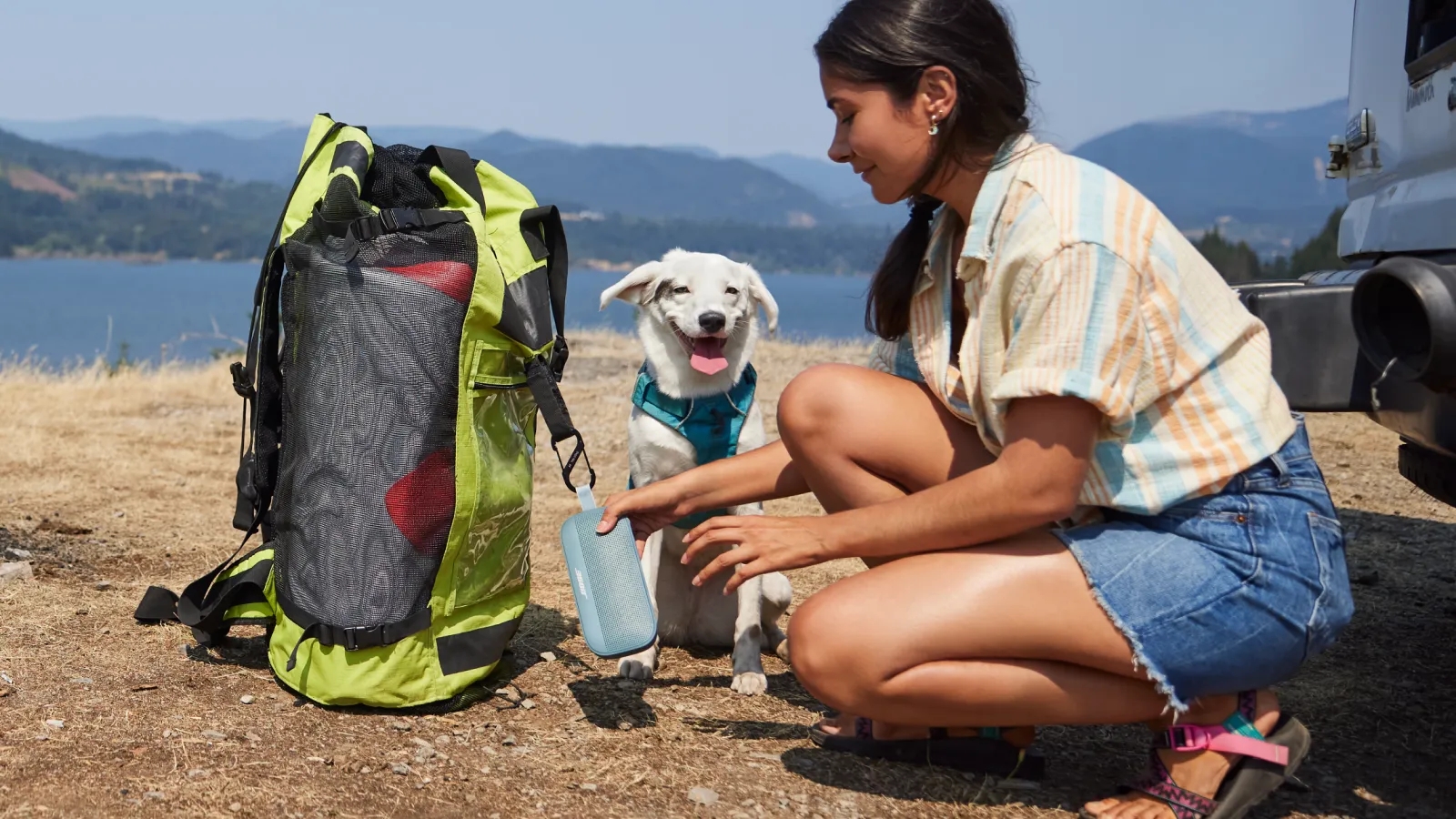 Woman with a Bose SoundLink Flex Bluetooth Speaker attached to her backpack