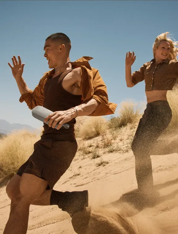 Two people enjoying the outdoors with a Bose portable speaker