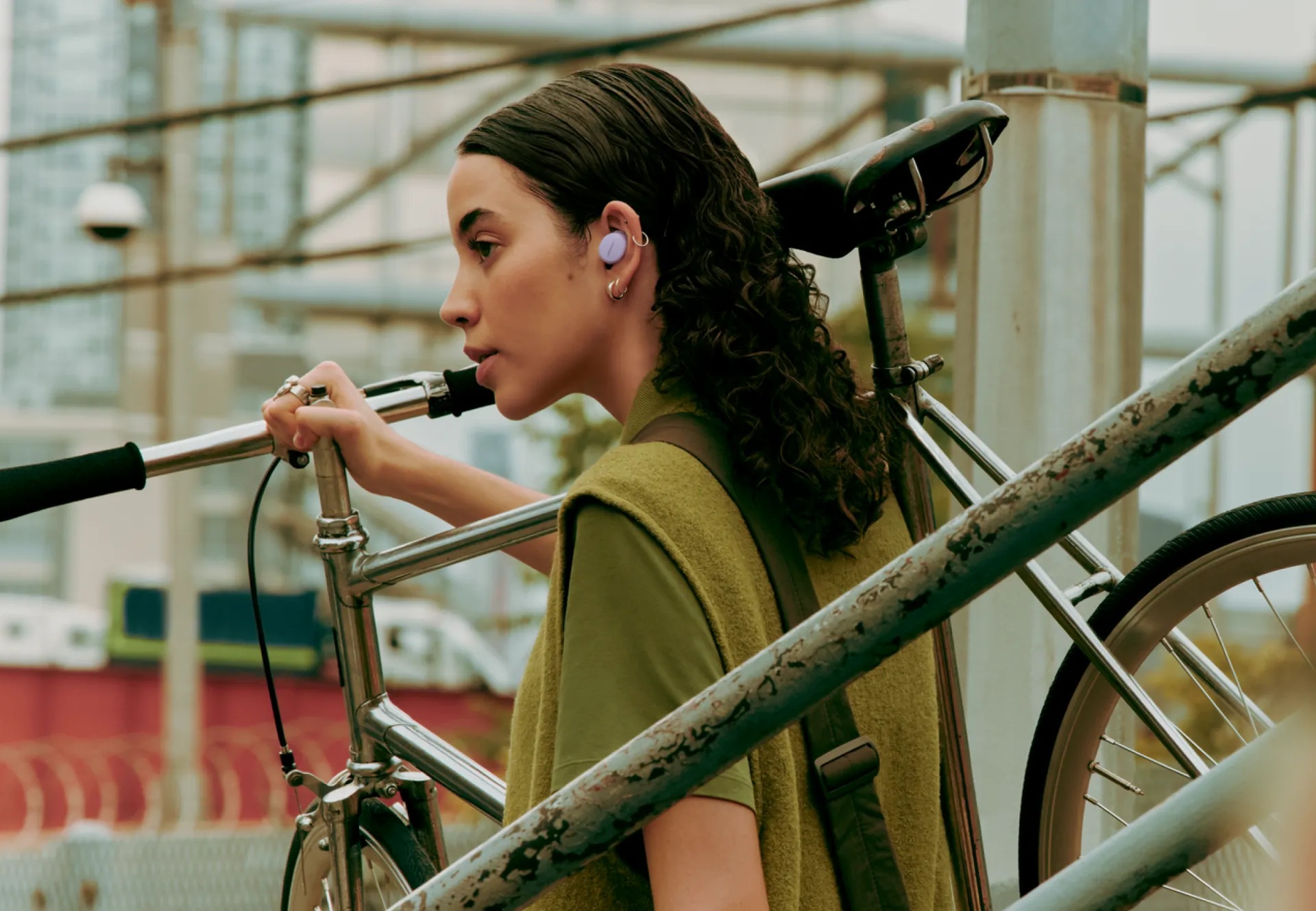 Woman holding a bike wearing Bose QuietComfort Earbuds