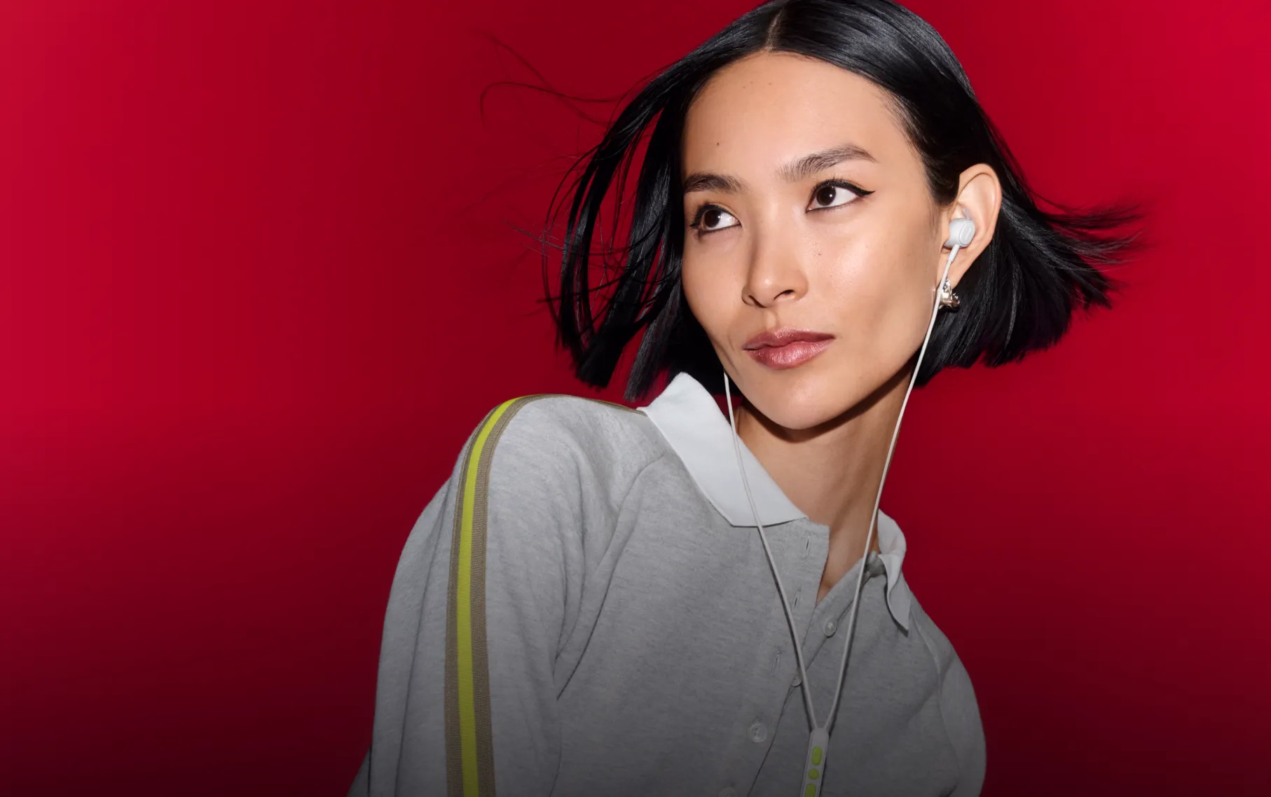 Eine Frau tr&auml;gt kabelgebundene Noise-Cancelling Earbuds von Bose.