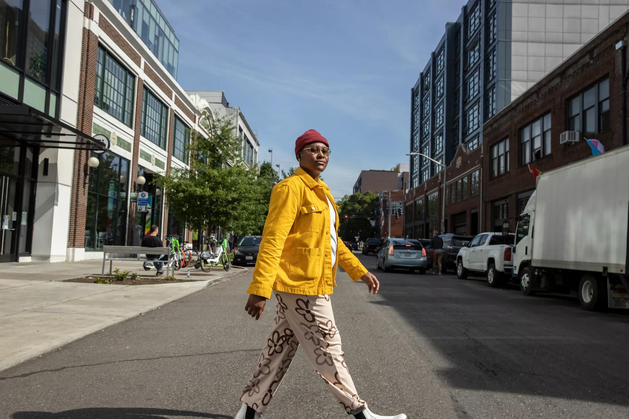 Une femme traverse la rue en portant des écouteurs Bose QuietComfort II