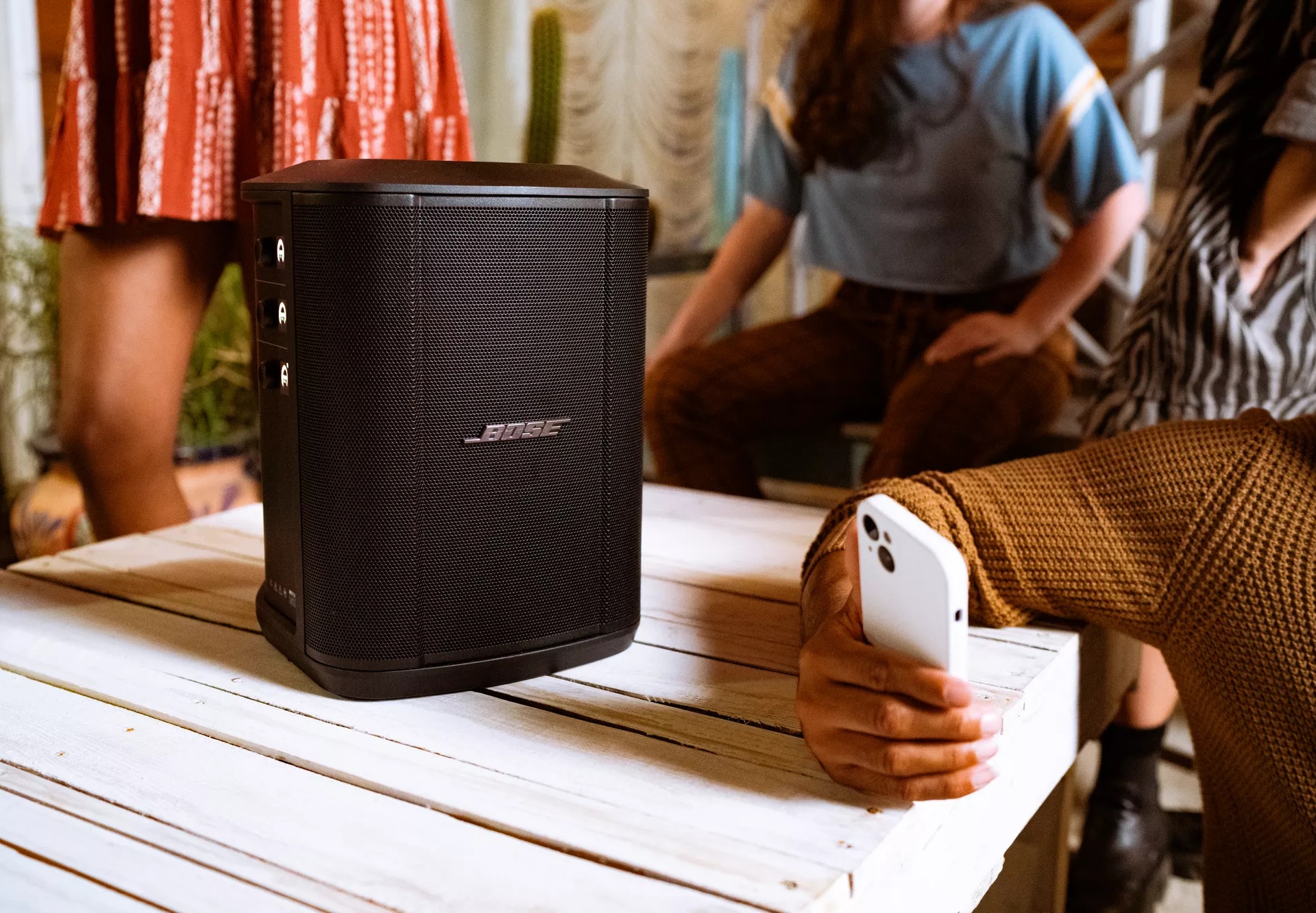 Bose S1 Pro+ Portable Bluetooth Speaker System sitting on table and person connected with their smartphone