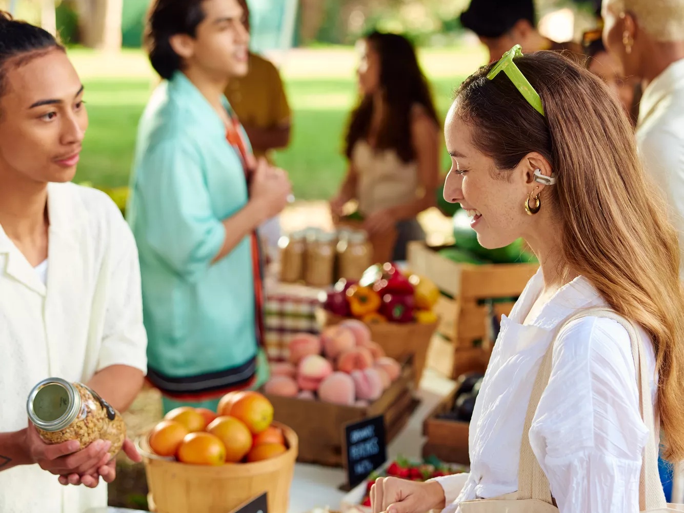 Woman shopping at farmers market while wearing Bose Ultra Open Earbuds