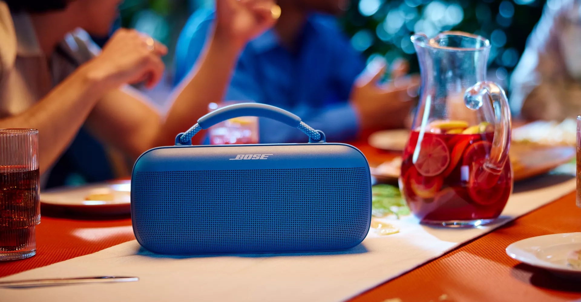 Bose SoundLink Max on a table at an outdoor barbeque