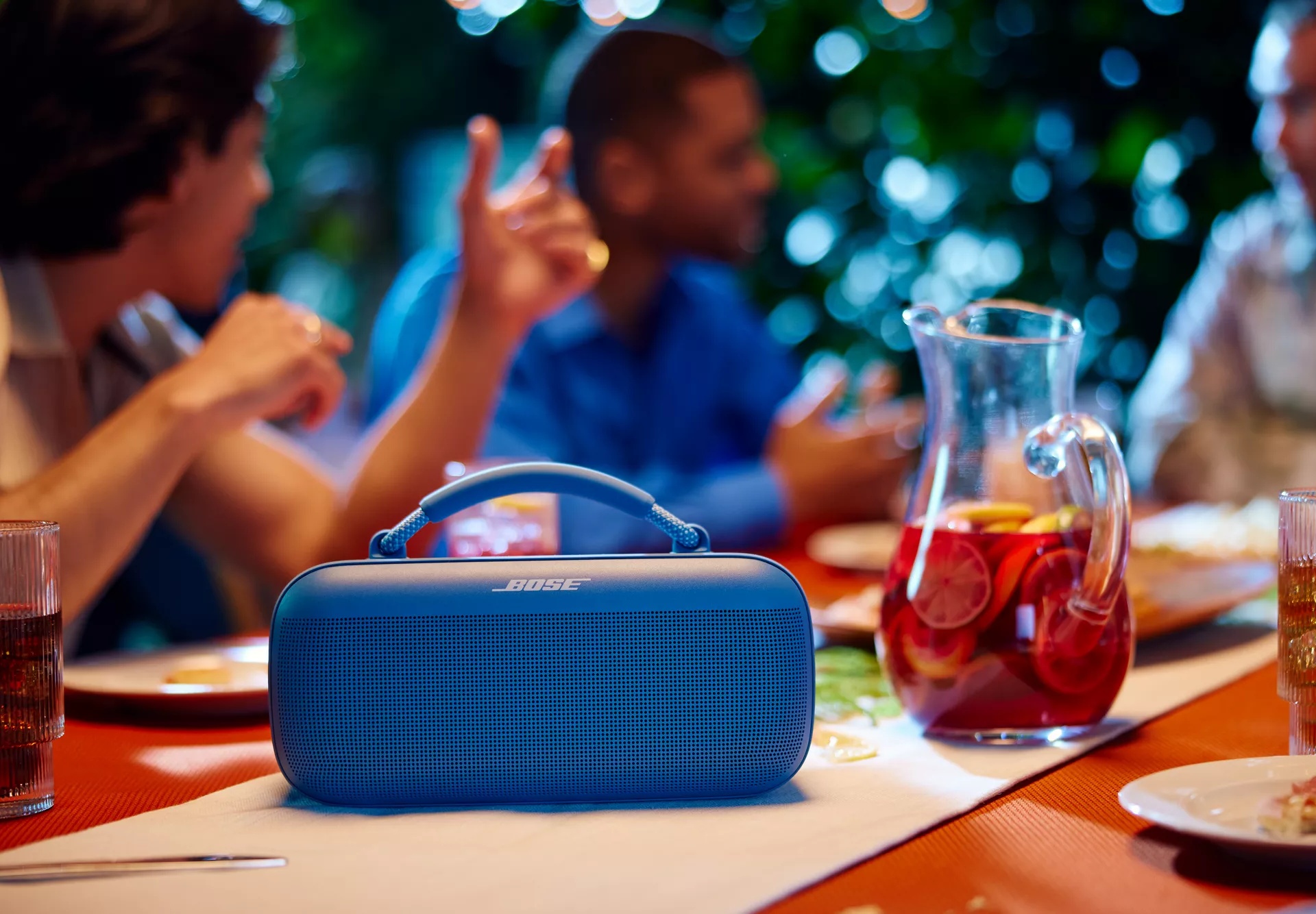 Une enceinte portative Bose SoundLink Max qui diffuse de la musique sur une table lors d’un barbecue à l’extérieur