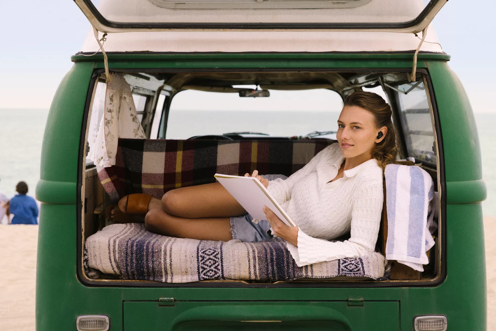 Woman wearing Bose QuietComfort Earbuds II in the back of an open van