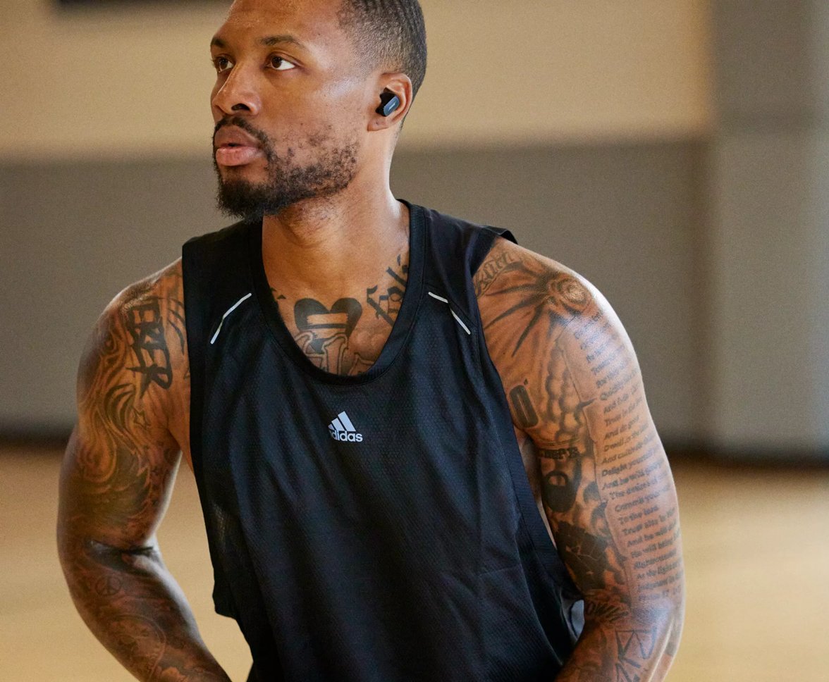 Damian Lillard devant une table d’écoute et Damian Lillard portant des écouteurs QuietComfort II de Bose