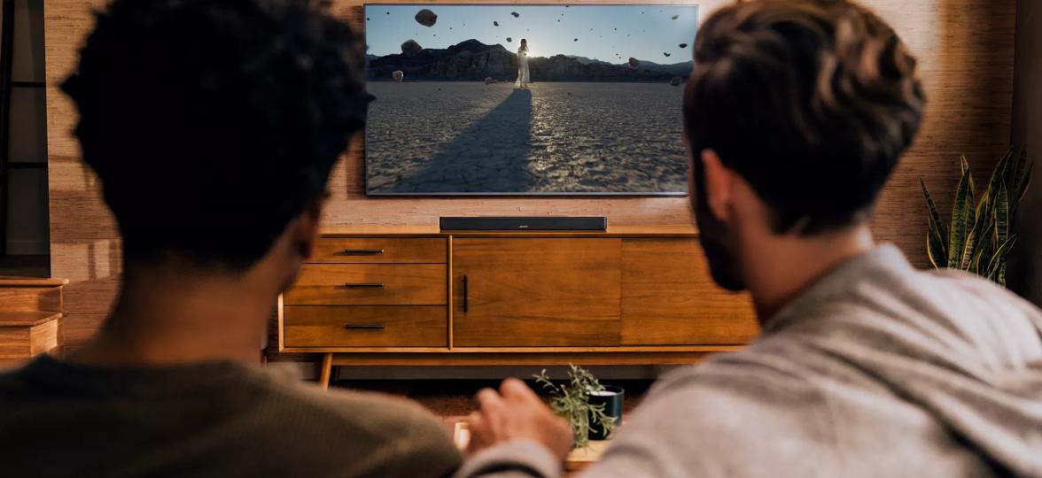Two men watching TV that has a Bose Smart Soundbar 900