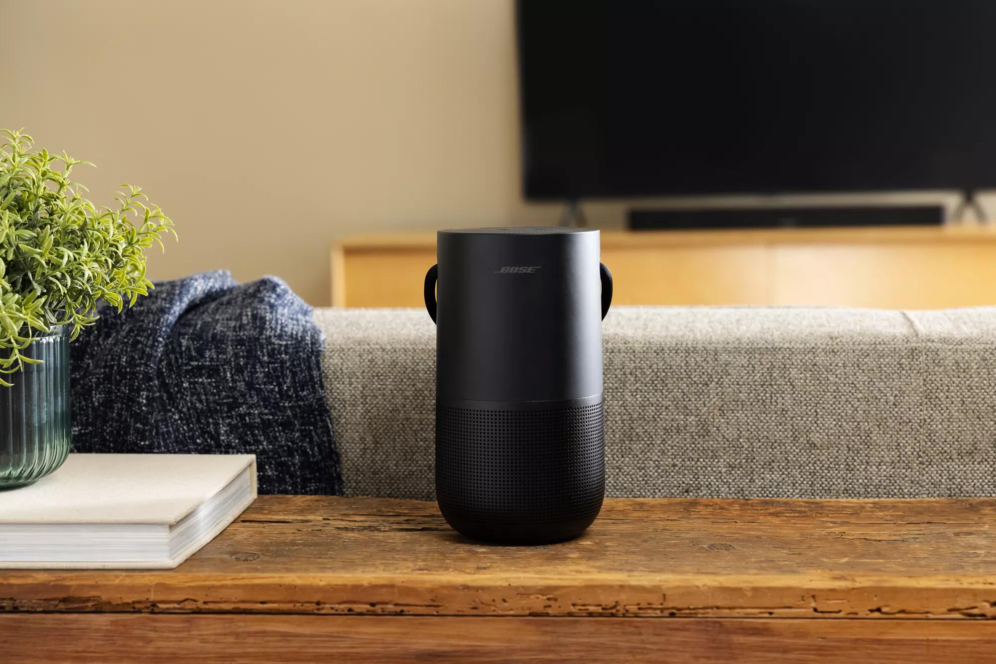 Bose Portable Smart Speaker sitting on table behind couch and TV